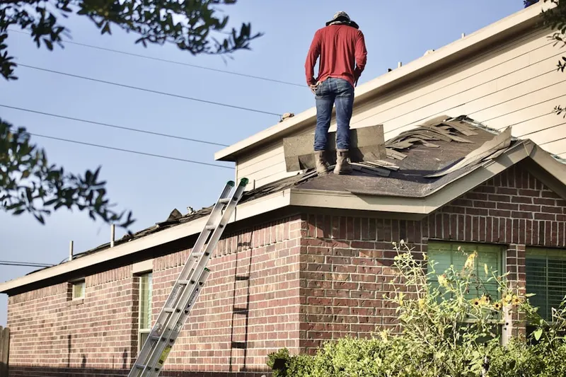 Professional roofer working on a residential roof in Kirby Woods